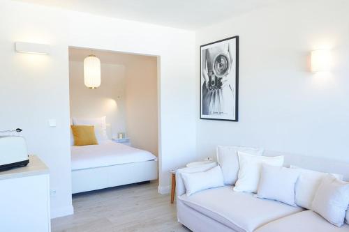 a white room with a bed and a couch at Ferienwohnung Sonnendeck mit Bergblick in Bad Reichenhall