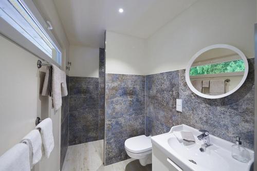 ein Badezimmer mit einem Waschbecken, einem WC und einem Spiegel in der Unterkunft Ferienwohnung Sonnendeck mit Bergblick in Bad Reichenhall