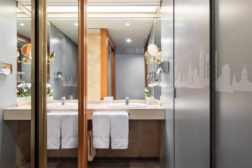 un baño con dos lavabos y dos espejos en Exe Coruña, en A Coruña
