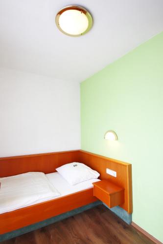 a bedroom with a bed and a light on the ceiling at Hotel-Dörfler Garni in Kahl am Main