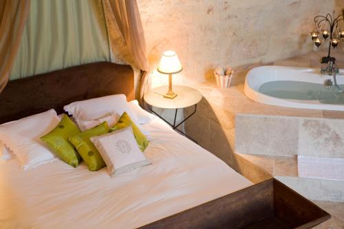 a bedroom with a bed with a tub and a lamp at Château Latour Segur Suites & Spa in Lussac