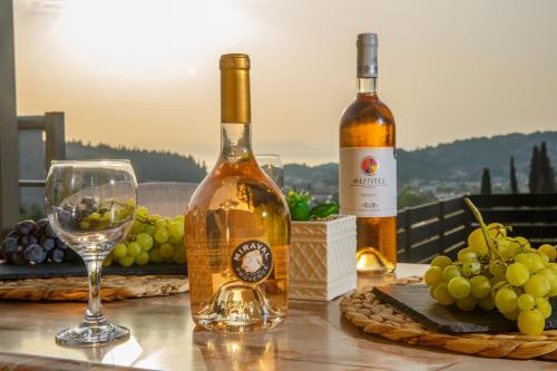 two bottles of wine sitting on a table with a glass at Théa boutique villas sivota I in Sivota