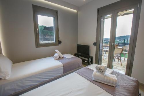 a hotel room with two beds and a balcony at Théa boutique villas sivota I in Sivota