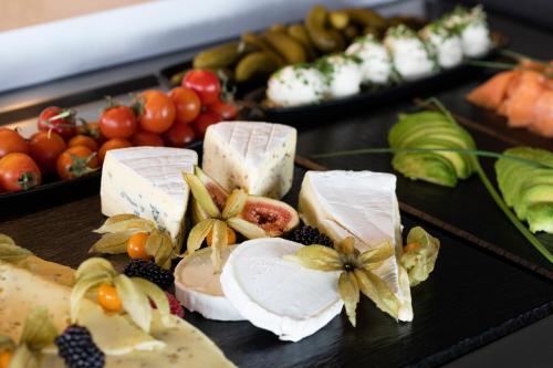 a table with different types of cheese and fruit at INNSiDE by Meliá Aachen in Aachen