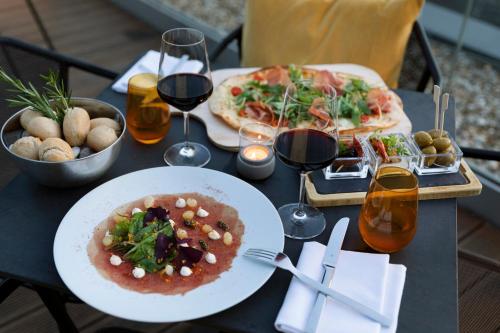 a table with two plates of food and glasses of wine at INNSiDE by Meliá Aachen in Aachen
