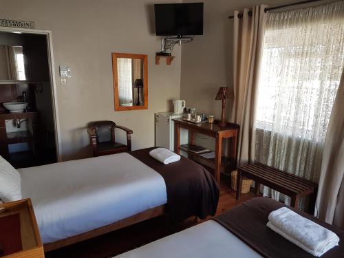 a hotel room with two beds and a window at Crane Cottage in Colesberg