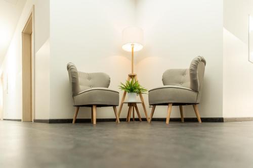 two chairs and a lamp in a room at Hotel Rösch in Klagenfurt