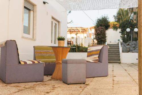 two chairs and a table on a patio at Hospedium Hostel República Surf House in Ericeira