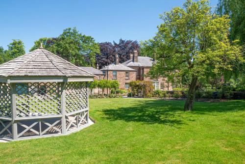 a gazebo in a yard with a tree at Oakhill Hotel in Matlock