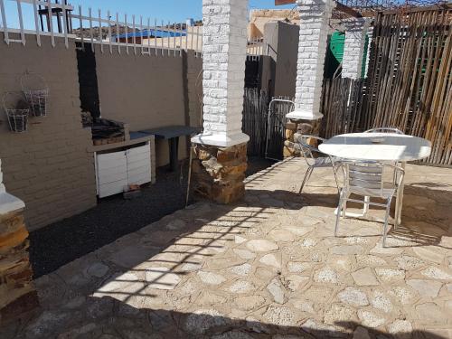 a patio with a table and chairs and a fence at Crane Cottage in Colesberg
