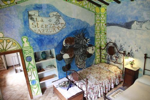 1 dormitorio con 1 cama con una pintura en la pared en Agriturismo Tisignana, en Roccastrada
