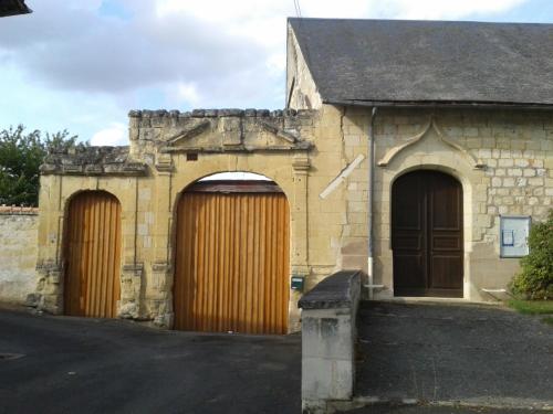 an old stone building with two wooden doors at The Piggeries at La Maison Tumtum Arbre in Loudun