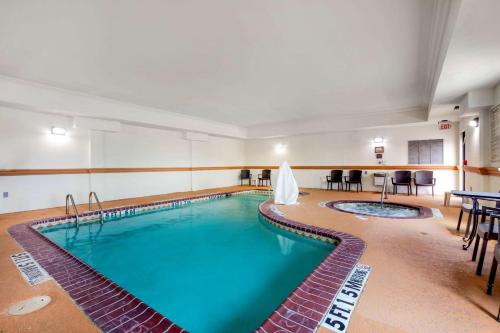 a large indoor pool in a hotel room with tables and chairs at Comfort Inn Near UNT in Denton