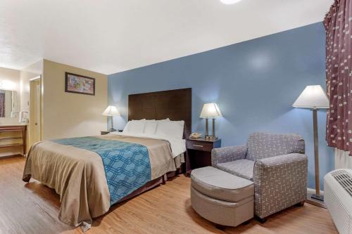 a hotel room with a bed and a chair at Econo Lodge Woodstock - Shenandoah Valley I-81 in Woodstock