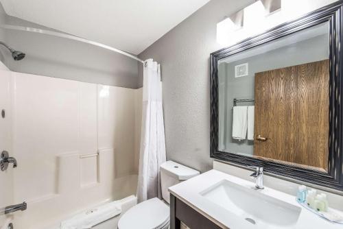 La salle de bains est pourvue d'un lavabo, de toilettes et d'un miroir. dans l'établissement Quality Inn Owatonna Near Medical Center, à Owatonna