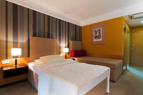 1 dormitorio con 1 cama, 2 mesas y 2 lámparas en IMPIQ Hotel, en Trnava