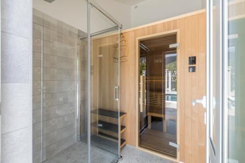 una puerta de ducha de cristal en una casa en Villa Grey Stone, en Gata
