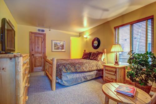 a bedroom with a bed and a table at Empire Coalition #106 in Park City
