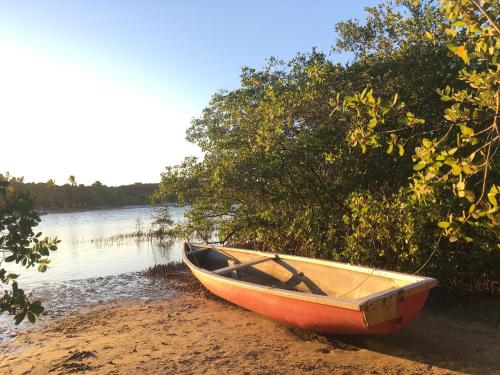 a boat sitting on the shore of a body of water at Pousada Spa Oasis in Caraíva