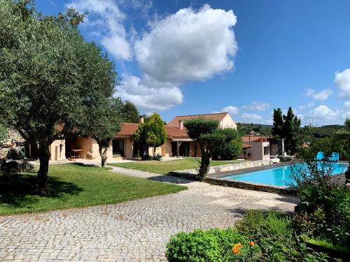 a house with a swimming pool in a yard at Villa Pedra Natural Houses in Alvorge