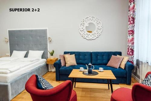 a living room with a blue couch and red chairs at Apartamenty Centrum - Mickiewicza in Bielsko-Biała