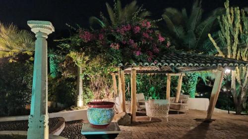 a wooden gazebo with a planter in a garden at night at Residenza Villa Spagnola in Parghelia