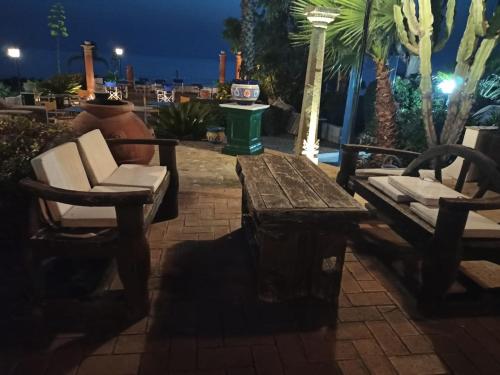 a wooden table and chairs on a patio at night at Residenza Villa Spagnola in Parghelia