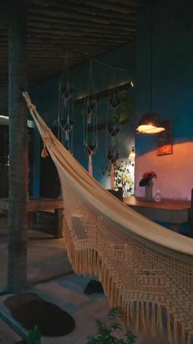 a hammock in a room with a table at Pousada Spa Oasis in Caraíva