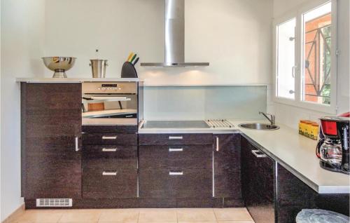 a kitchen with wooden cabinets and a sink in it at Gorgeous Home In Bédarieux in Bédarieux