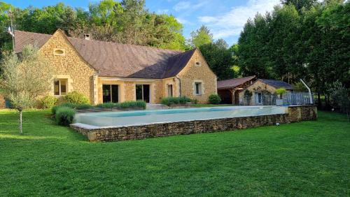 une maison avec une piscine dans la cour dans l'établissement Villa Les jardins de Raiatea, à Sarlat-la-Canéda