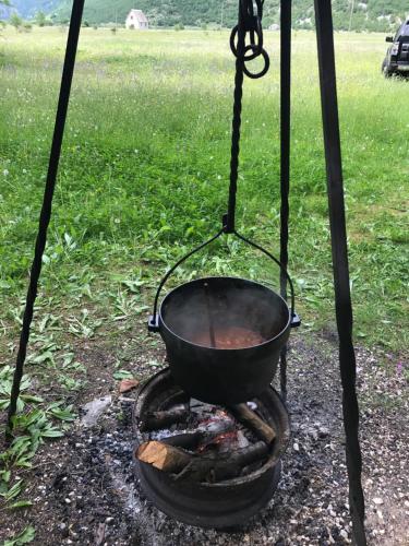 un pot sur un foyer dans l'établissement Mountain Cottage Komarnica, à Šavnik