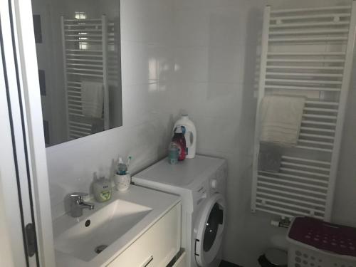 une salle de bain avec un lavabo et une machine à laver dans l'établissement T2 Hendaye Plage, à Hendaye