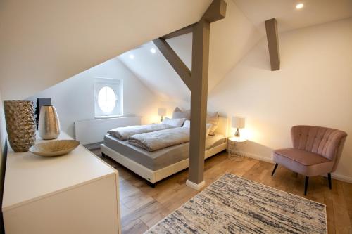 ein Schlafzimmer mit einem Bett und einem Stuhl in der Unterkunft Wohnperle Apartment Adele in Dresden