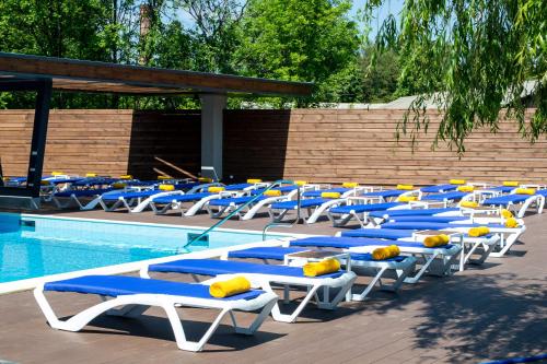 a row of blue and white lounge chairs next to a swimming pool at RiverSide- Restaurant, Hotel, Beach in Chernihiv
