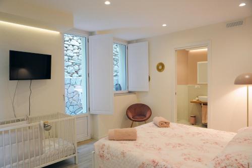 a bedroom with a bed and a tv and a window at la casa di Gaia in Taormina