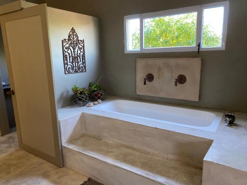 a large bath tub in a bathroom with a window at Gelukkie in Paternoster