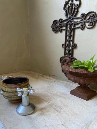 a cross and a potted plant on a table at Gelukkie in Paternoster