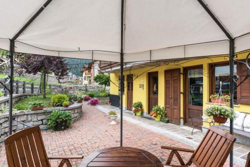 a patio with two chairs and an umbrella at Appartamento Albachiara 2 in Ossana