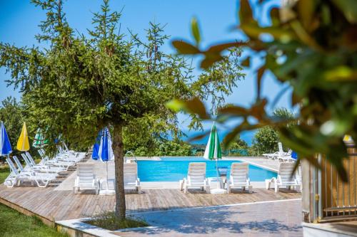 a group of chairs and umbrellas next to a swimming pool at Agva Teras Garden Hotel & Bungalow in Agva