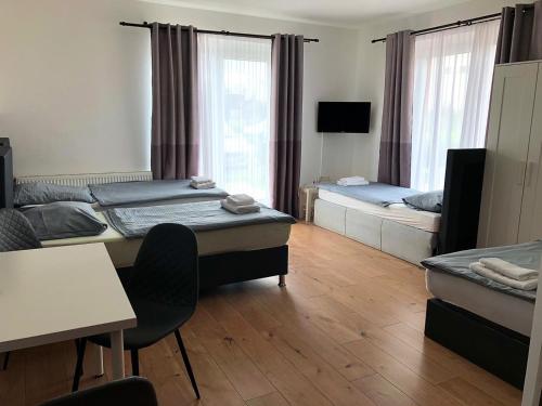 a room with two beds and a table and chairs at Pension Lara in Magdeburg