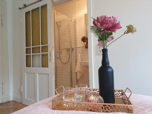 a black vase with a pink flower on a table at Boutique Hotel Villa Horbach in Idar-Oberstein