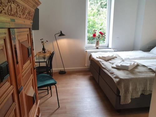 a bedroom with a bed and a desk and a window at Boutique Hotel Villa Horbach in Idar-Oberstein