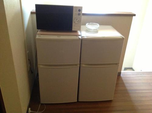 a microwave sitting on top of a refrigerator at Rusutsu Lodges Pension Lilla Huset in Rusutsu