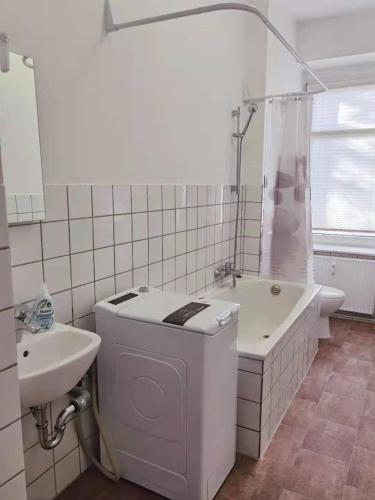 łazienka z toaletą, umywalką i wanną w obiekcie Gemütliches Apartment Nähe Hauptbahnhof w Lipsku