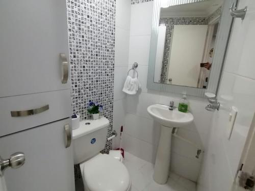 Baño blanco con aseo y lavamanos en Apartamento Boutique Cartagena, en Cartagena de Indias