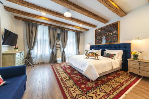 a bedroom with a large bed and a blue couch at Nikolas Haus in Braşov
