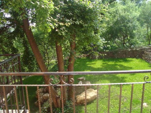 a gate in a yard with trees and grass at Villa Mari Guest Rooms in Golden Sands