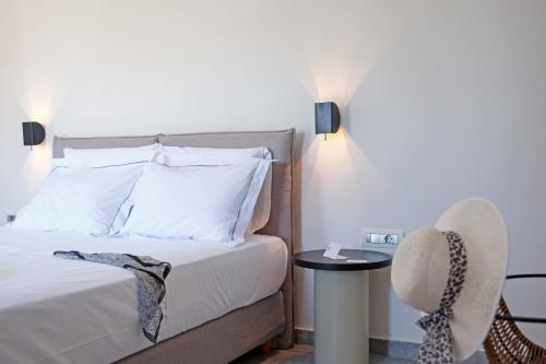 a bedroom with a bed with a table and a chair at Margo Beach Hotel in Gythio