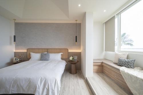 - une chambre avec un grand lit et une fenêtre dans l'établissement 日軸蒔光, à Hualien
