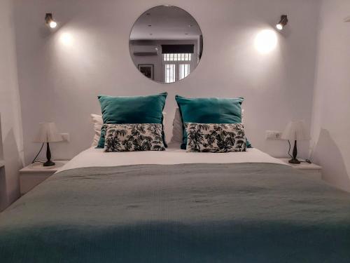 1 dormitorio con 1 cama grande y espejo en Living4Malaga Loft San Francisco, en Málaga